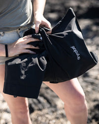 Female outdoors packing Tech-Lite Dryrobe® into pouch