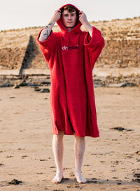 Young man wearing organic Dryrobe® towel on the beach