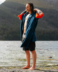 *MALE* by water wearing Dryrobe® Zip towel (blue orange)