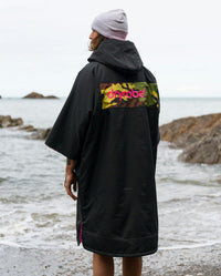 Adult male on beach wearing Dryrobe® Black pink camo remix