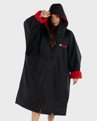 Woman wearing dryrobe Advance Long Sleeve changing robe in Black Red with hood and zip up