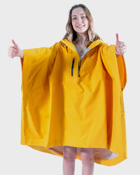 Girl wearing Yellow Kids dryrobe® Waterproof Poncho holding her thumbs up