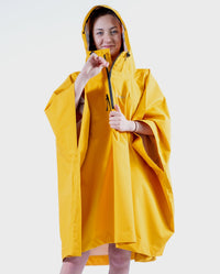 Girl wearing Yellow Kids dryrobe® Waterproof Poncho doing up the zip
