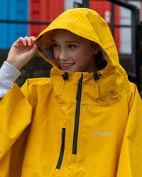 Close up of girl wearing Yellow Kids dryrobe® Waterproof Poncho with hood up