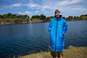 Joanna Shimwell stood next to a lake wearing a Cobalt Blue dryrobe Advance