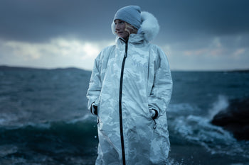 A woman in a White Camo Dryrobe stood in front of the sea