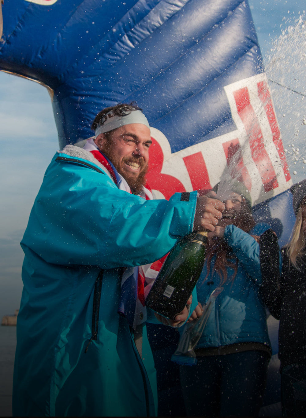 Ross Edgley wearing Dryrobe® and celebrating after becoming first person to swim around Great Britain 