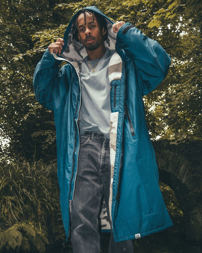 *MALE* standing next to bridge wearing AW25 Blue Dryrobe¬Æ advance long sleeve