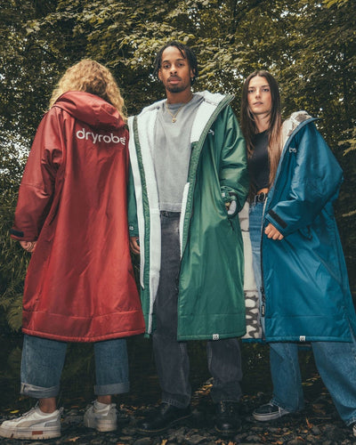 *MALE* and females Female standing by trees wearing AW25 Green, Blue and Burgundy Dryrobe¬Æ advance long sleeve's