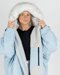 Close-up of woman wearing dryrobe Advance Long Sleeve Alpine Range change robe in Alpine Ice Blue, pulling hood up