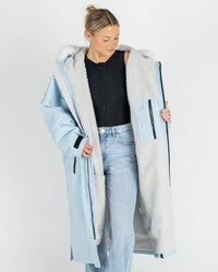 Woman wearing dryrobe Advance Long Sleeve Alpine Range change robe in Alpine Ice Blue showing the inner lining