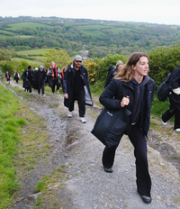 Group of people walking on a trail with a scenic landscape in the background