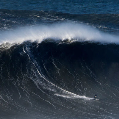Andrew Cotton surfing a large wave in the ocean