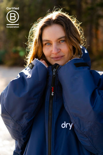 Person wearing a blue Dryrobe, standing outdoors.