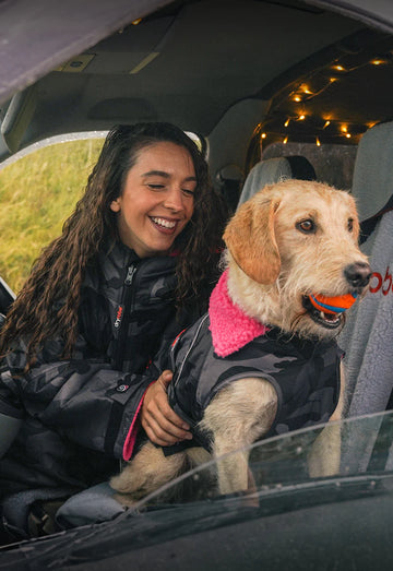Woman and dog sat in van wearing Dryrobes