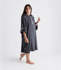 Woman wearing a dark gray dryrobe with a white logo on a white background