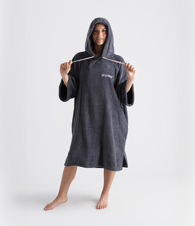 Person wearing a grey hooded towel with 'dryrobe' branding on a white background