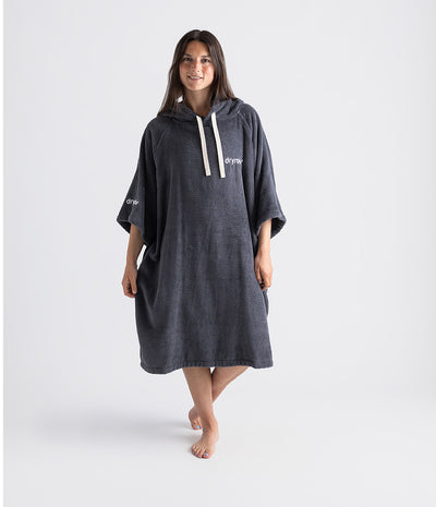 Person wearing a dark grey hooded towel with 'dryrobe' branding on a white background