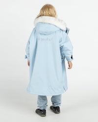 Child with back to the camera, wearing dryrobe Advance Long Sleeve Alpine Range changing robe in Alpine Ice Blue 