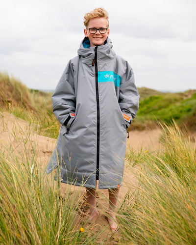 Child on sand dunes wearing LTD edition 2025 RNLI Dryrobe® Advance long sleeve