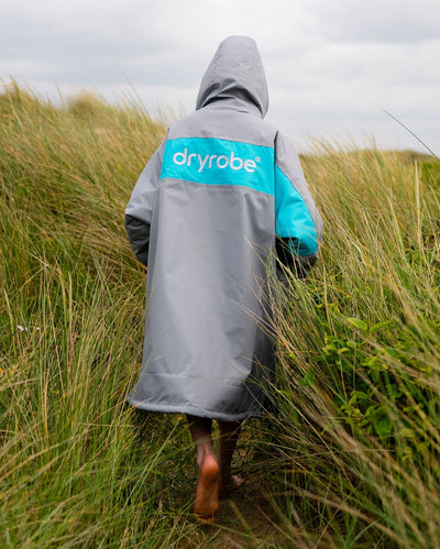 Kid on sand dunes wearing LTD edition 2025 RNLI Dryrobe® Advance long sleeve