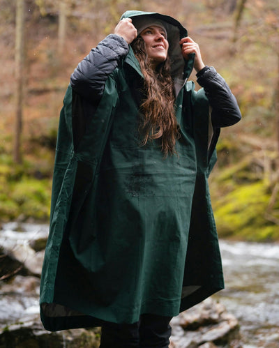 female wearing Dryrobe® green poncho in front of river