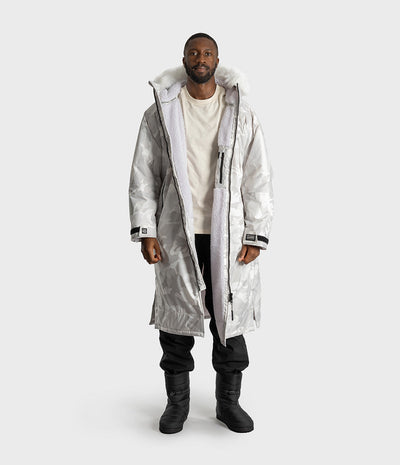 *MALE* A man modeling a white hooded Dryrobe over a cream t-shirt, black pants, and black boots, set against a solid light gray background.