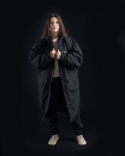 *FEMALE* Person wearing a black Nexus coat on a black background
