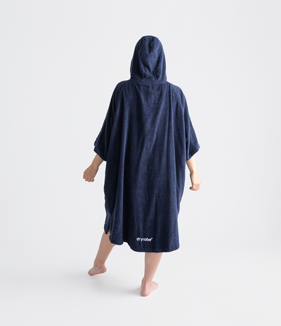 Person wearing a navy blue hooded towel robe on a white background