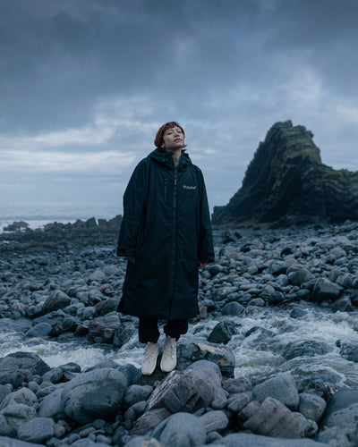 *FEMALE*Person standing on rocky terrain with a dark, moody sky
