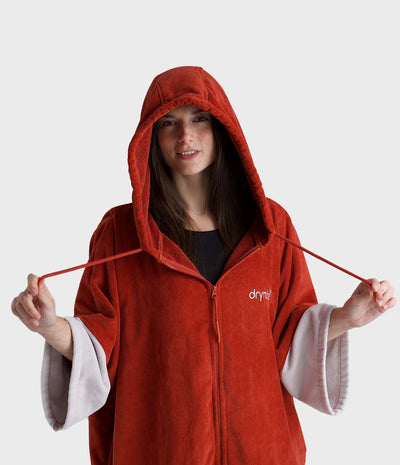 Person wearing a red poncho with a hood on a white background