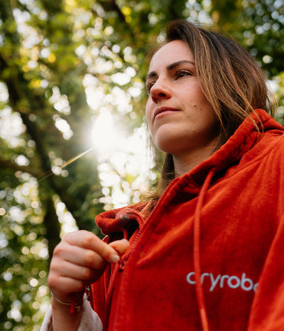 Person wearing a red Cryrobin jacket in a forest setting