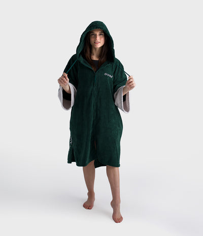Person wearing a green hooded poncho with 'dreamp' branding on a white background