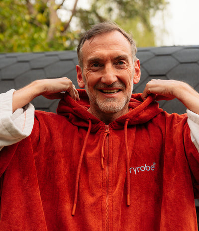 *MALE* Man wearing a red hoodie with 'ryrobe' logo, standing outdoors.