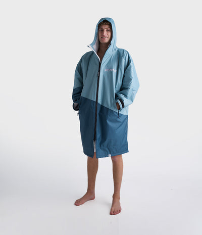 *MALE* Person wearing a blue hooded Dryrobe and shorts on a white background