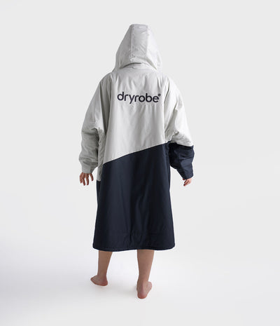 Person wearing a grey and navy dryrobe with 'dryrobe' branding on a white background