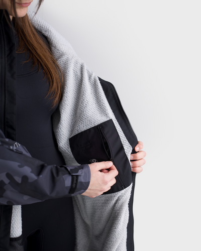 Person wearing a black and gray jacket with a white background