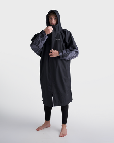 *MALE*Person wearing a black raincoat with a hood on a white background