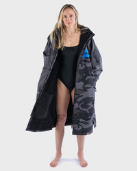 Woman wearing dryrobe Advance Long Sleeve REMIX Range change robe in Black Camo Black Blue unzipped 

