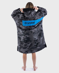 Woman with back to the camera wearing dryrobe Advance Long Sleeve REMIX Range change robe in Black Camo Black Blue
