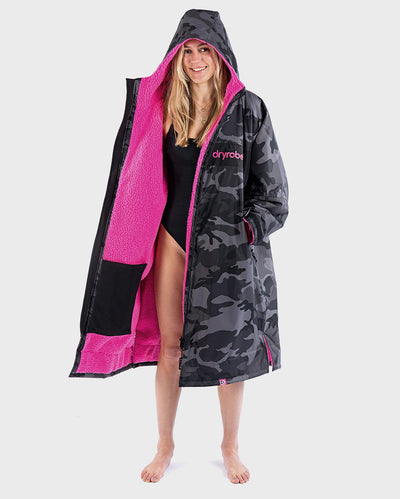 Woman smiling wearing dryrobe Advance Long Sleeve REMIX Range change robe in Black Camo Pink Black with hood up 