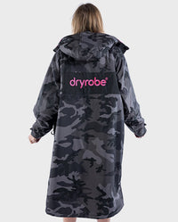 Woman with back to the camera wearing dryrobe Advance Long Sleeve REMIX Range change robe in Black Camo Pink Black