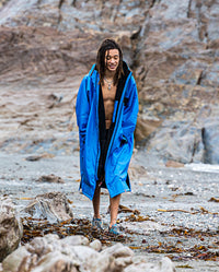 Man walking on a beach, wearing Cobalt Blue Black dryrobe® Advance Long Sleeve REMIX Range