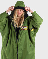 Woman pulling hood up on dryrobe Advance Long Sleeve REMIX Range change robe in Forest Green Black Camo