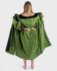 Woman standing with back to the camera, wearing  dryrobe Advance Long Sleeve REMIX Range change robe in Forest Green Black Camo