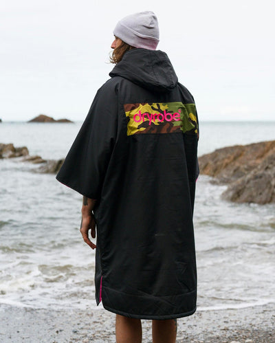 Adult male on beach wearing Dryrobe® Black pink camo remix