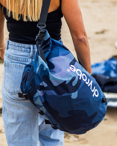 Close up of dryrobe Compression Travel Bag in Blue Camo being carried on the beach 