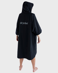 Woman with back to the camera, wearing dryrobe® Lite changing robe