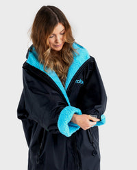 Woman pulling down sleeve on Black Blue dryrobe® Advance Long Sleeve