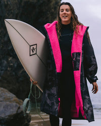 dryrobe Ambassador Lucy Campbell wearing dryrobe Advance holding surfboard